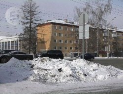 На парковке у ТЦ «Сигма» рабочие зарыли в снег мешки с неизвестными отходами
